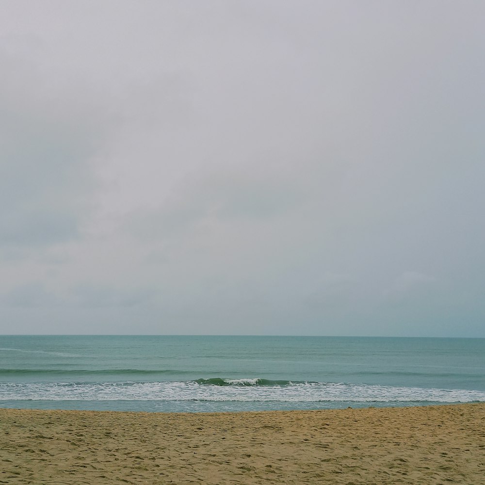 sea waves crashing on shore during daytime