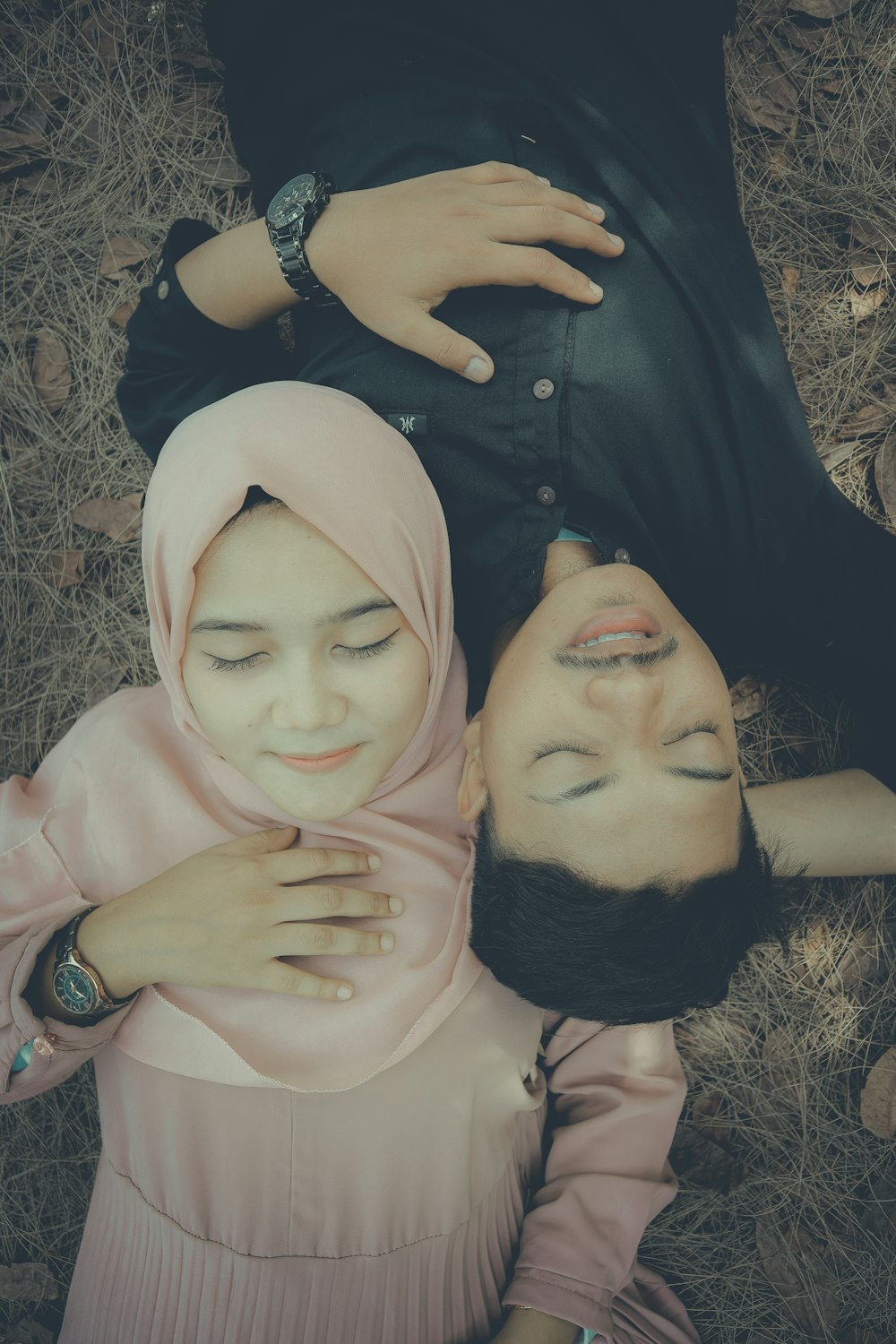 woman in black button up shirt lying on brown grass