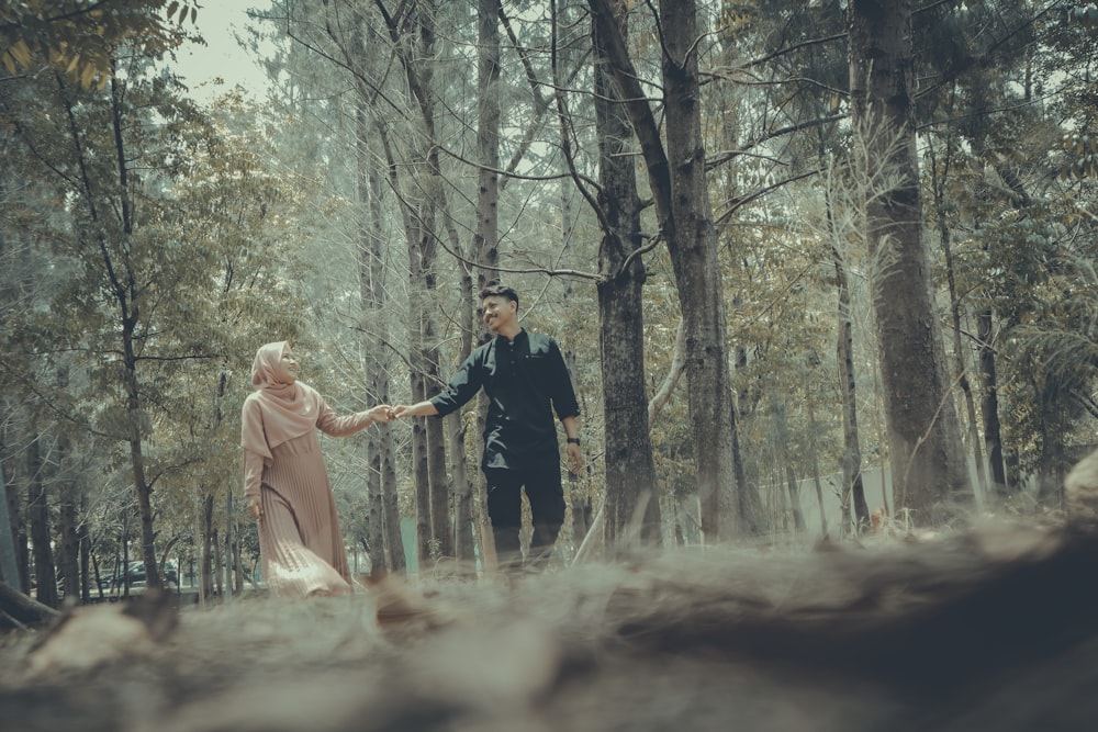 man and woman standing on forest during daytime