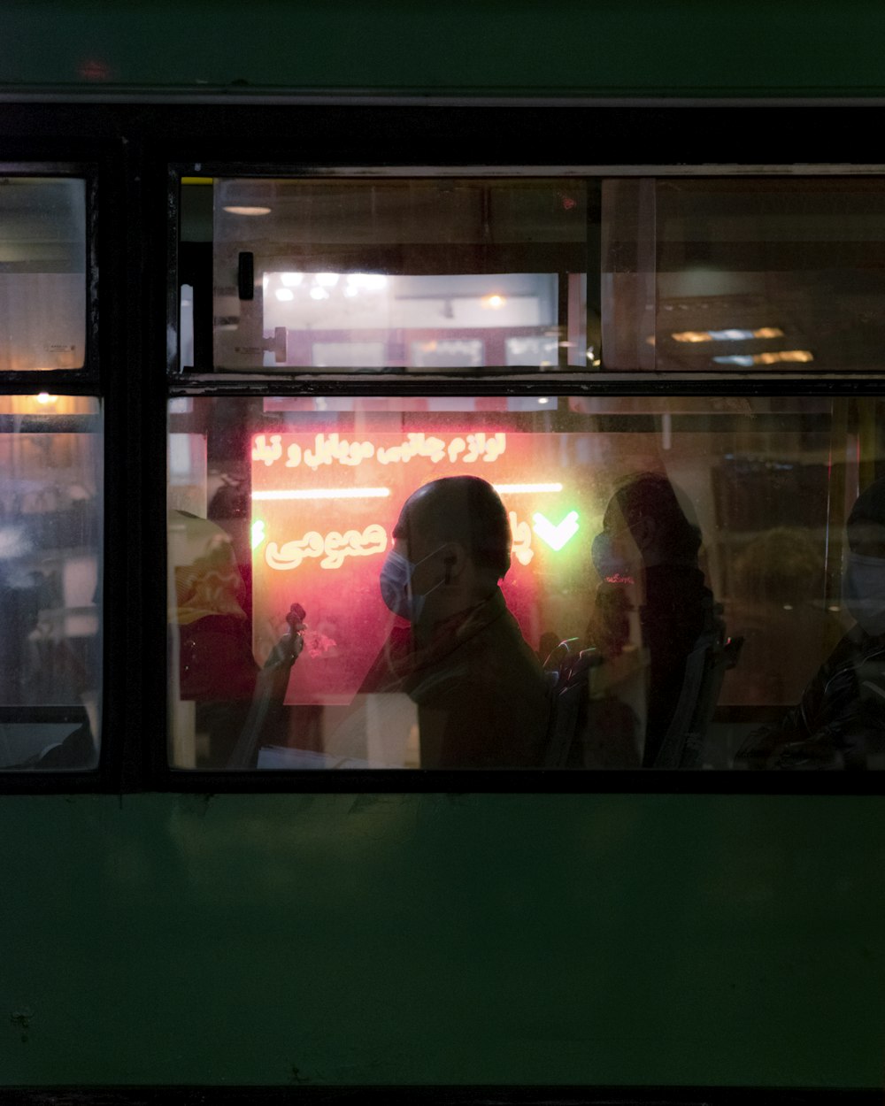 Mujer con chaqueta negra de pie junto a la ventana de vidrio