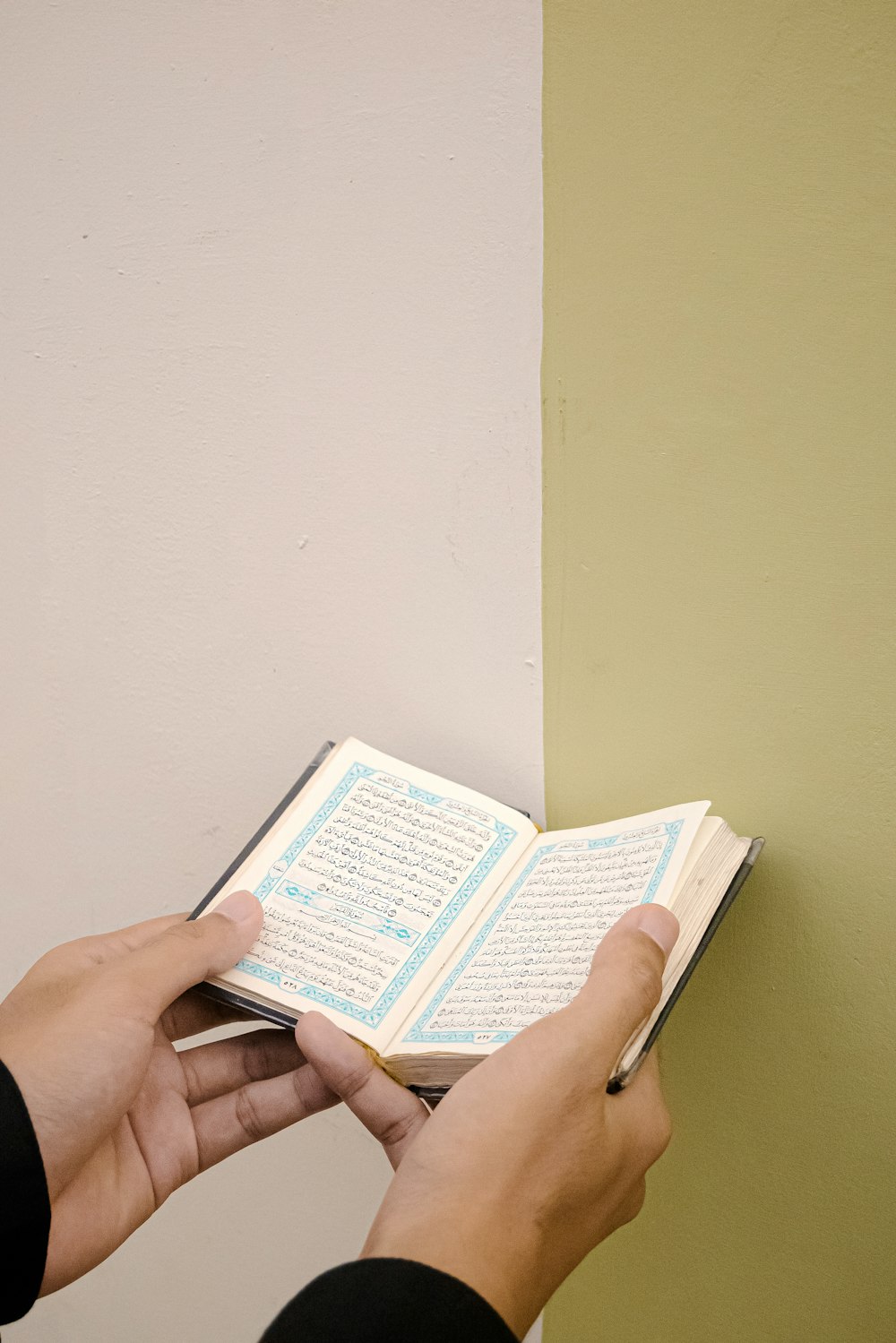 person holding white and blue book