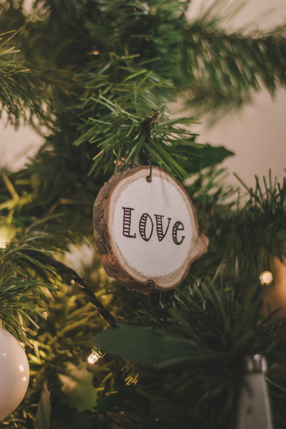 green pine tree with brown and white christmas bauble