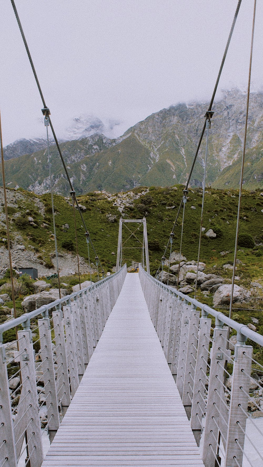 white wooden hanging bridge over the mountains