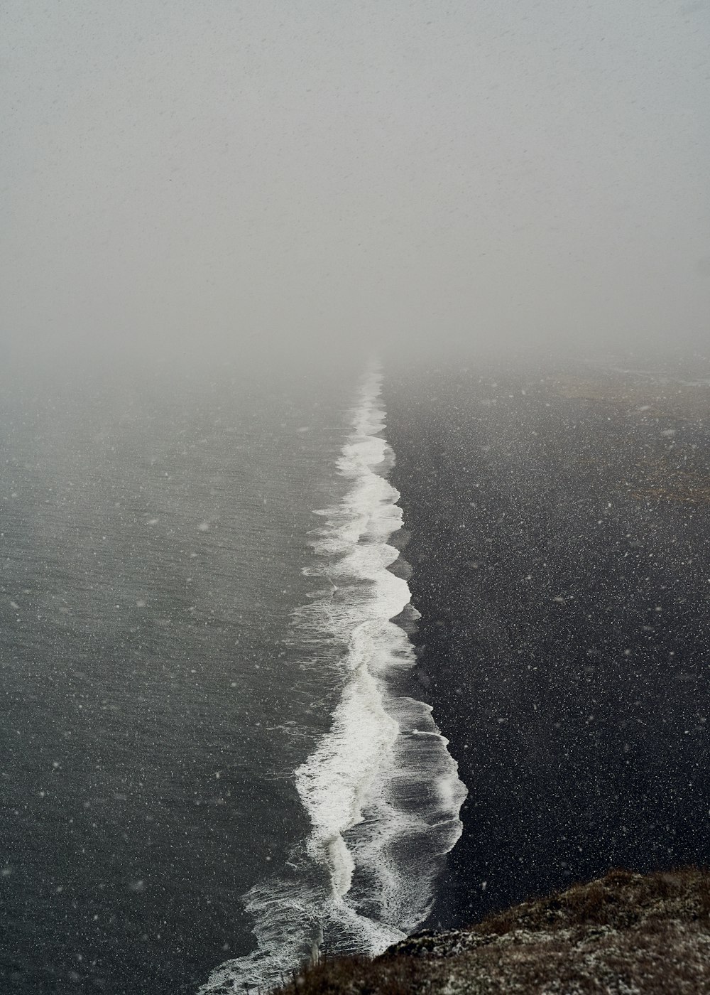 body of water under white sky during daytime