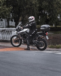 man in black motorcycle helmet riding motorcycle on road during daytime