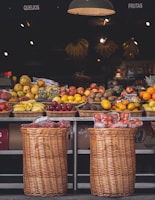 A bright, airy market stall showcasing a variety of fresh fruits in simple baskets.