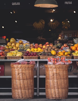 A bright, airy market stall showcasing a variety of fresh fruits in simple baskets.