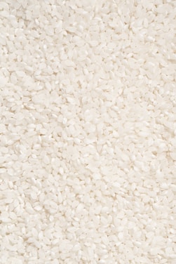 Close-up of polished rice grains flowing smoothly through advanced sorting machinery.