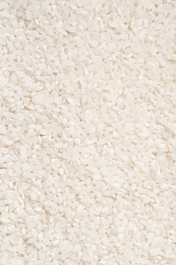 Close-up of polished rice grains flowing smoothly through advanced sorting machinery.