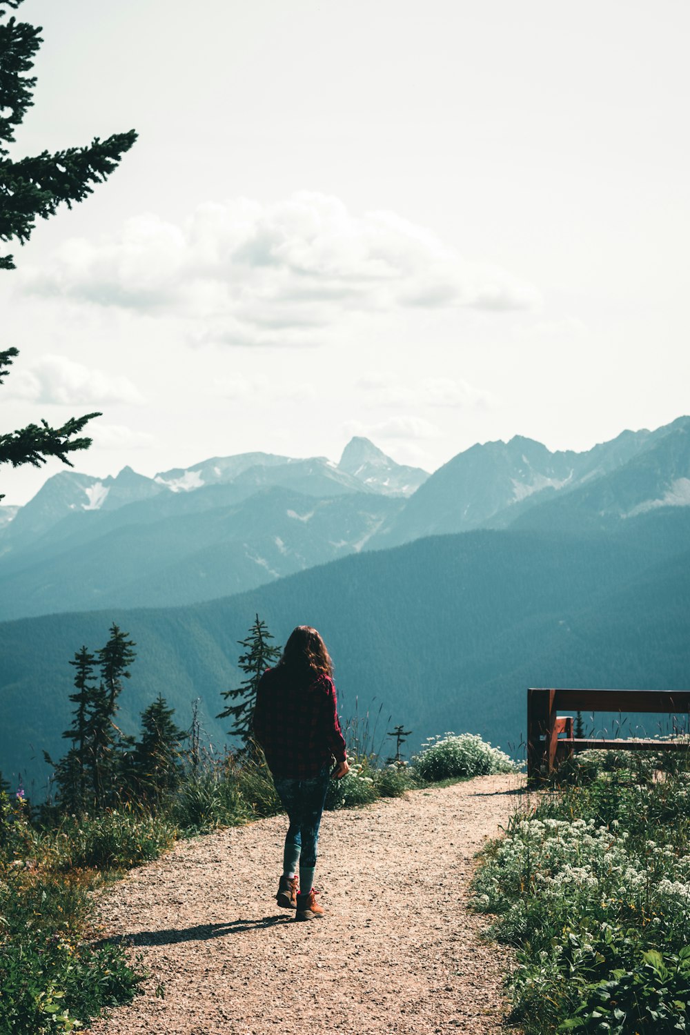 woman in black jacket standing on brown wooden fence during daytime