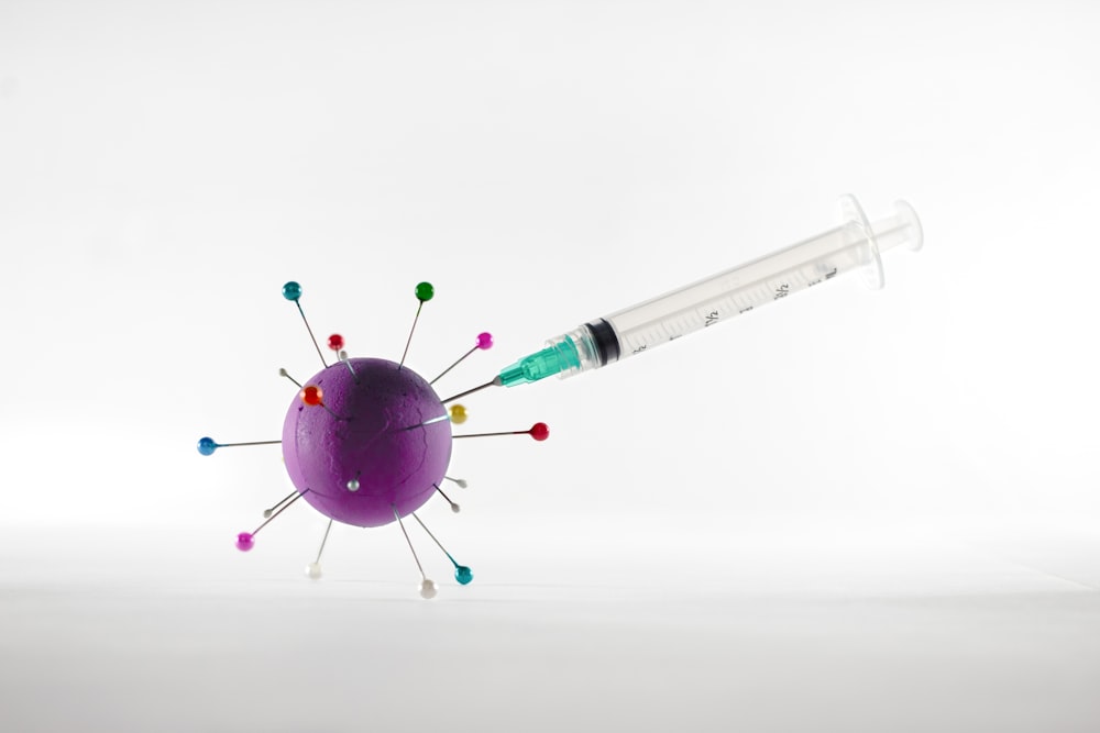 white and green syringe on white surface