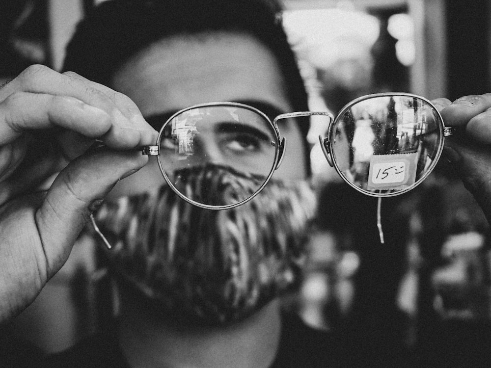 woman holding magnifying glass in grayscale