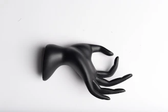 Hands holding a smooth, matte-finished 3D printed decorative piece in black and white.