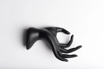 Hands holding a smooth, matte-finished 3D printed decorative piece in black and white.