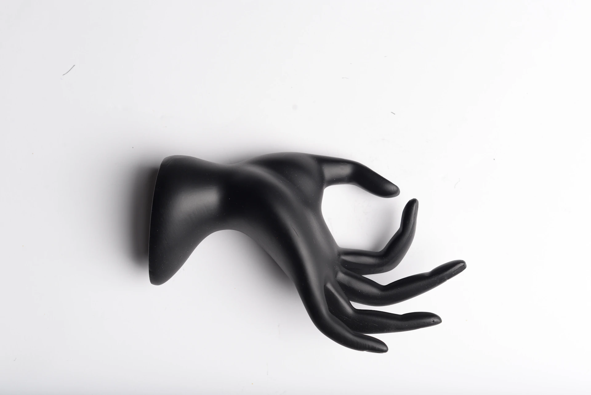 An elegant black-and-white portrait highlighting the textures and contrasts of a handcrafted sculpture in a minimalist setting.