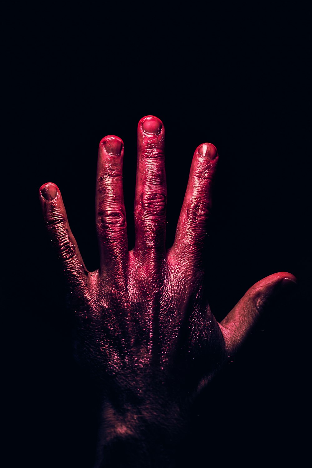 a person's hand with red paint on it