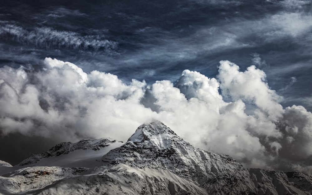 nuages blancs au-dessus de la montagne enneigée