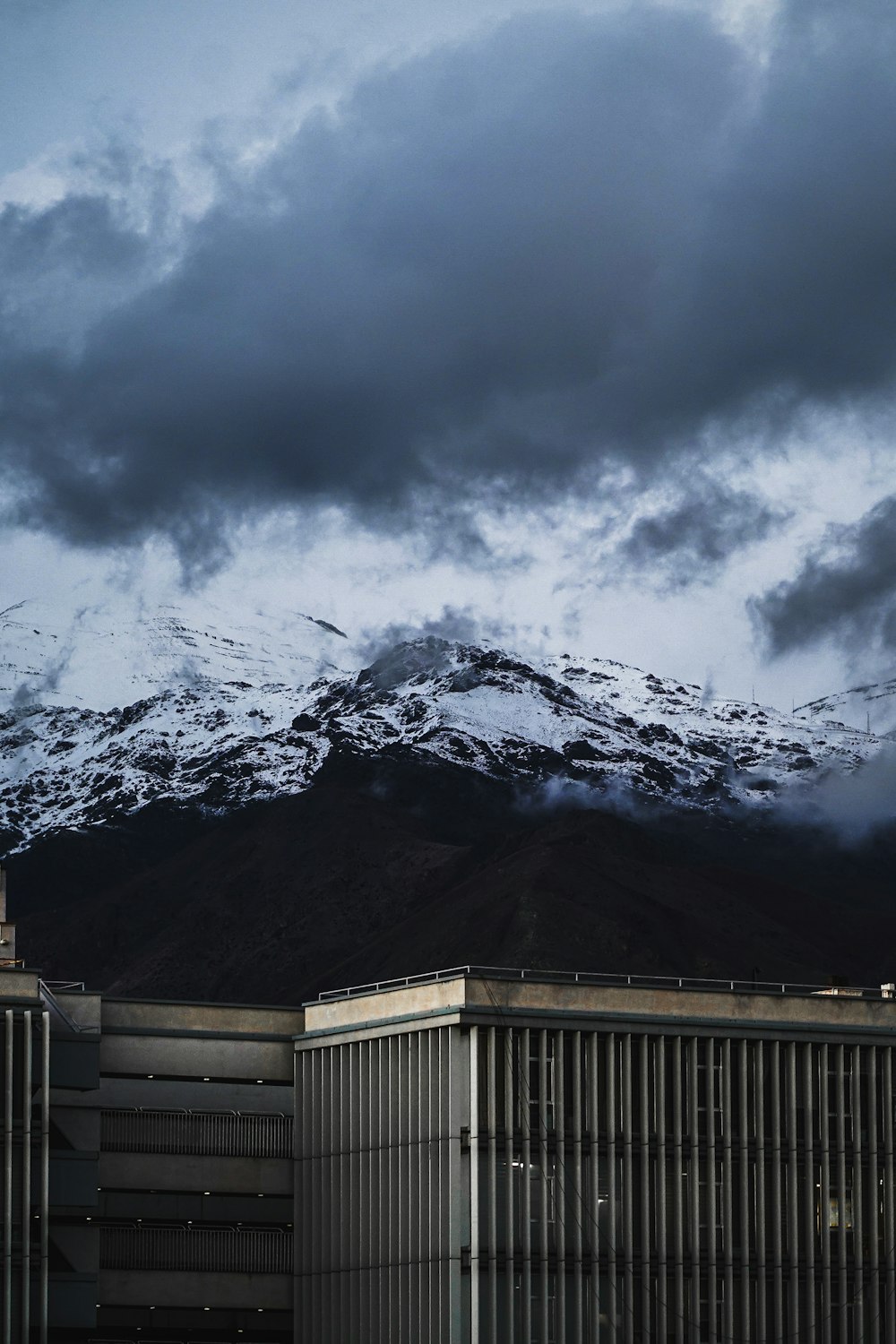 montanha coberta de neve sob céu nublado durante o dia