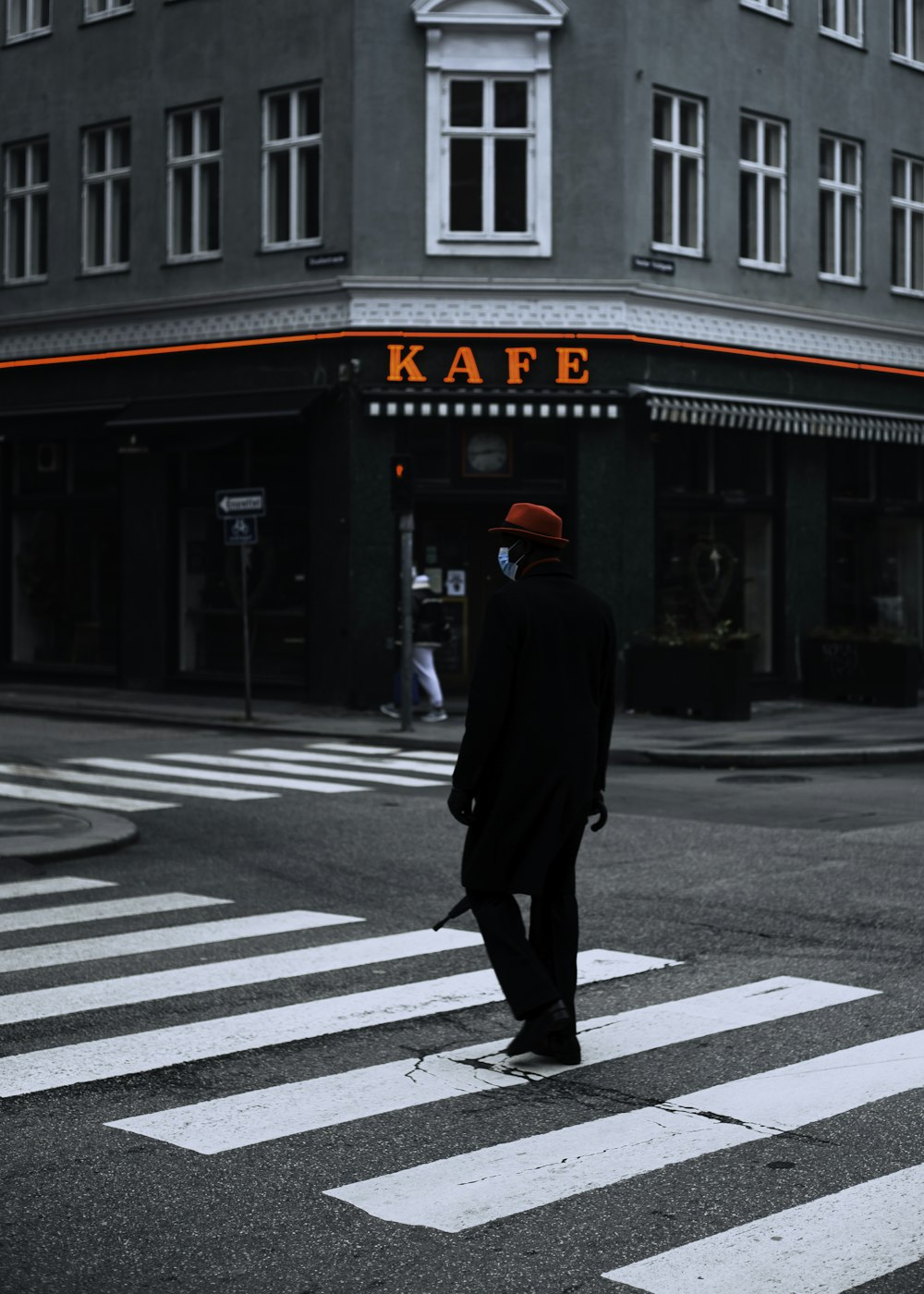 man in black coat walking on pedestrian lane during daytime