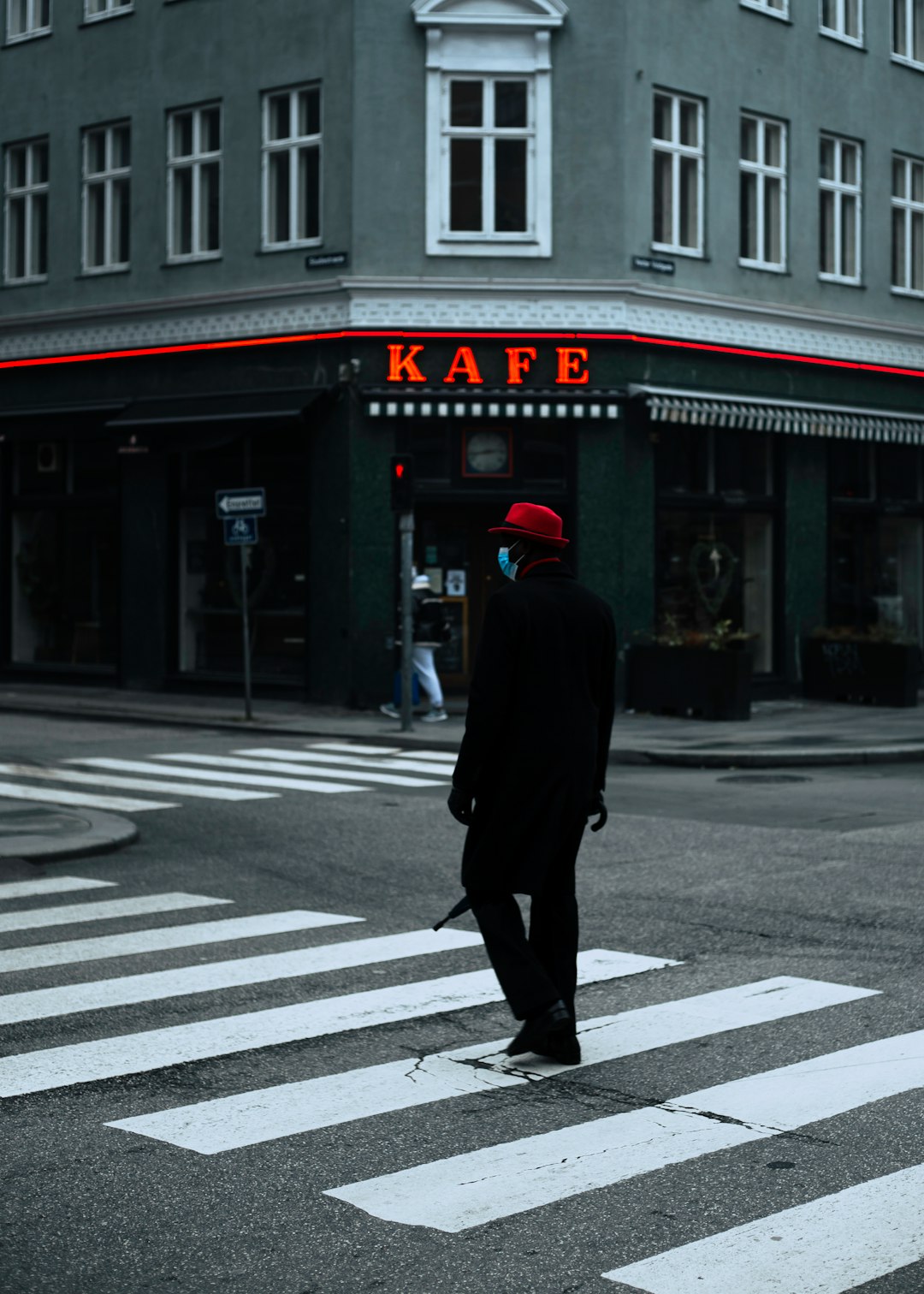 man in black coat walking on pedestrian lane during daytime