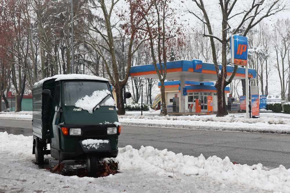 green and white car on snow covered road during daytime