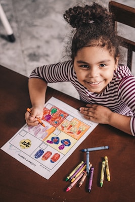 boy in black and white striped crew neck t-shirt holding white and red labeled box
