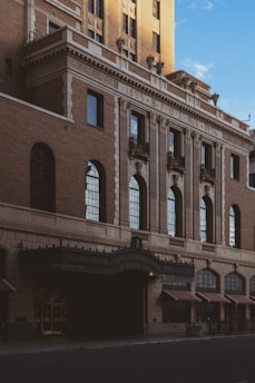 Historic brick facade of Long Pine Lodge No. 136 at sunset, with warm light glowing from the windows.