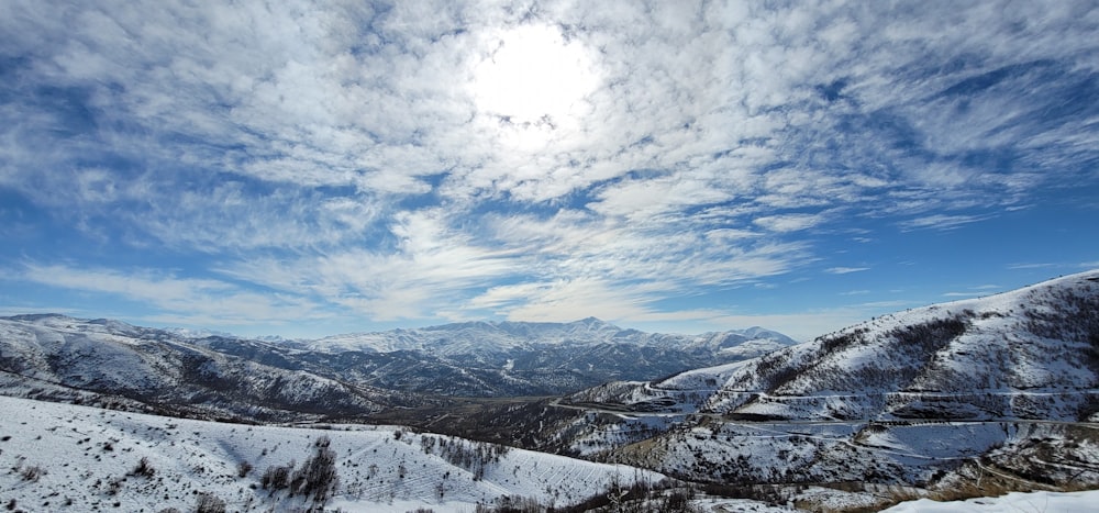 昼間は青い空と白い雲に覆われた雪に覆われた山々