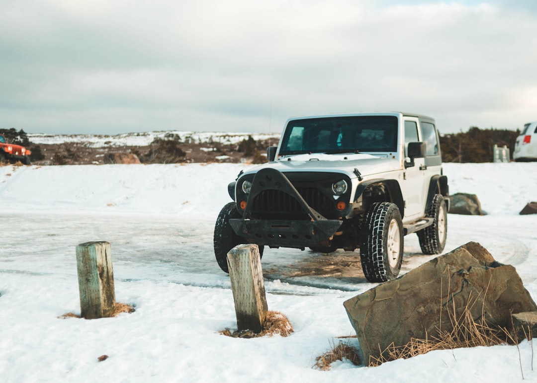 black and white jeep wrangler on snow covered ground during daytime