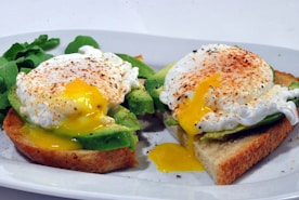 bread with egg and avocado vegetable on white ceramic plate