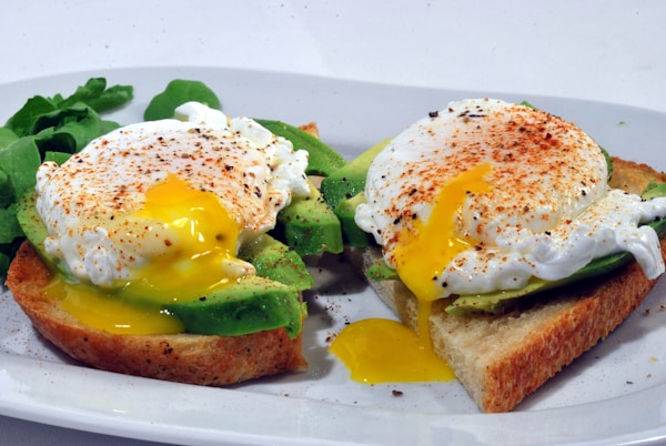 Bread with egg and vegetable on white ceramic plate