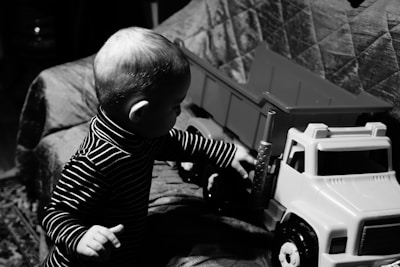 grayscale photo of baby in striped long sleeve shirt