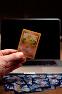 A collector carefully examining a rare Pokémon card under a magnifying glass.