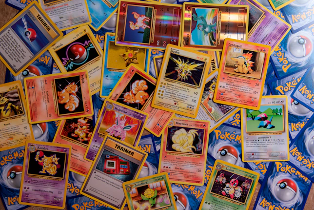 A collection of colorful Pokemon trading cards scattered across a flat surface