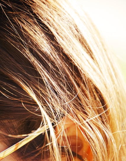 A close-up of healthy hair strands with natural light reflecting off them.