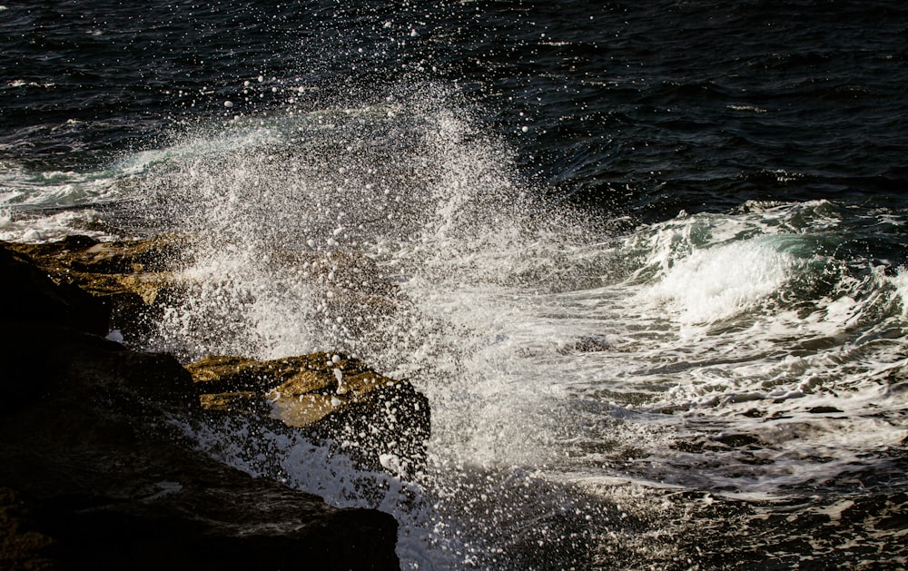 ocean waves crashing on brown rock