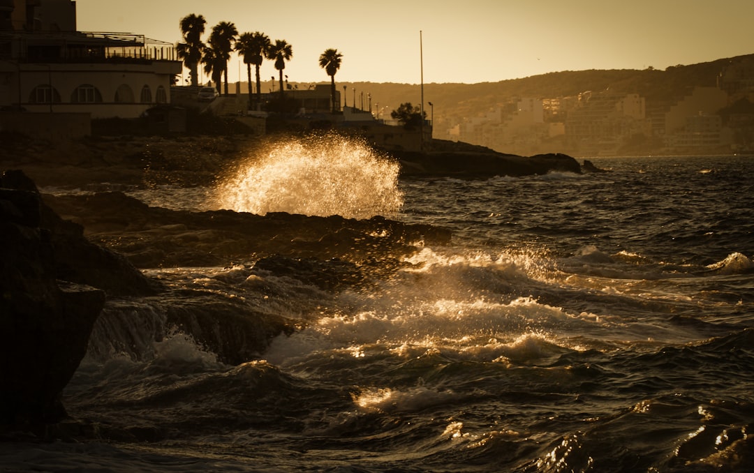 people standing on rock formation near sea water during daytime