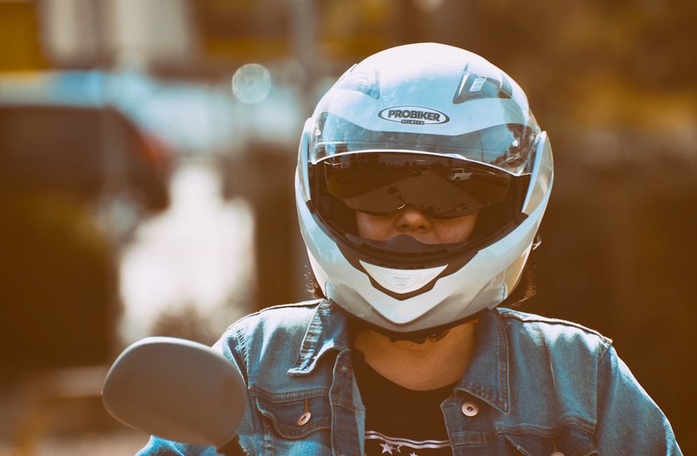 person wearing blue denim jacket and white helmet