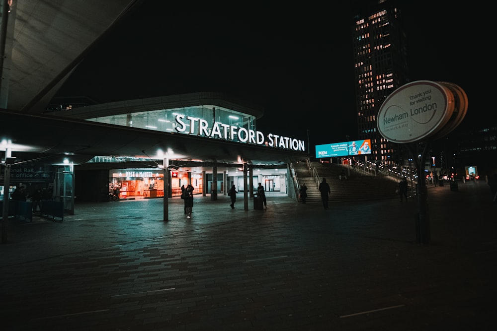 people walking on sidewalk during night time