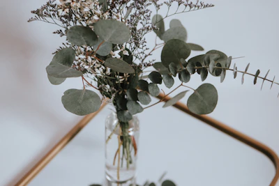 An intimate corporate gathering with minimalist decor featuring eucalyptus leaves and warm grey tones.