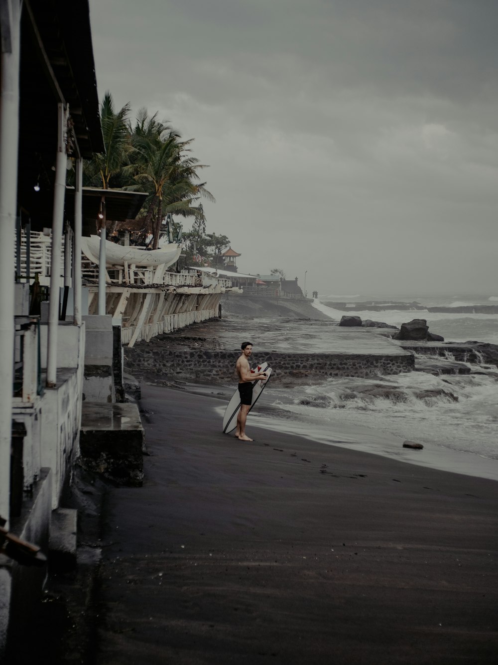 woman in black tank top walking on beach during daytime