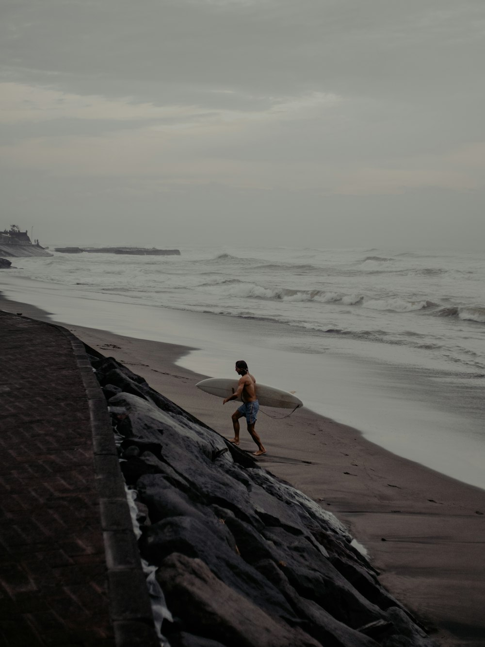 woman in blue tank top and black shorts standing on gray concrete dock during daytime