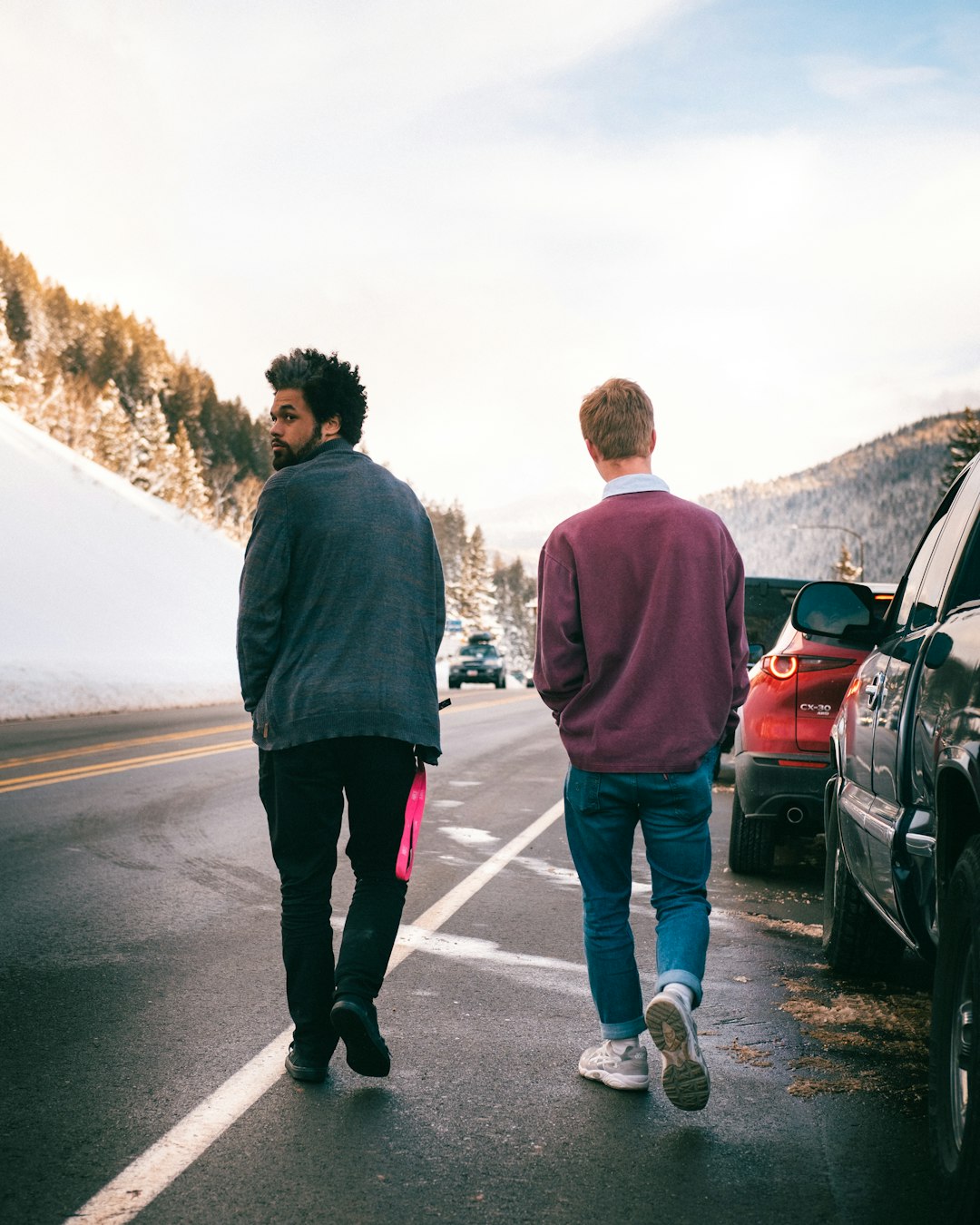 man in gray hoodie standing beside woman in red jacket