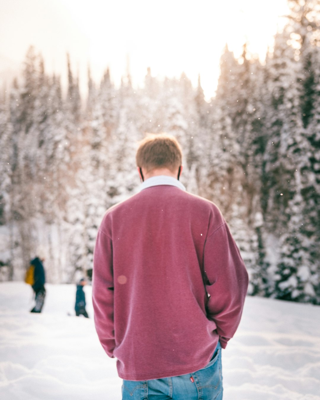 man in red coat walking on snow covered ground during daytime