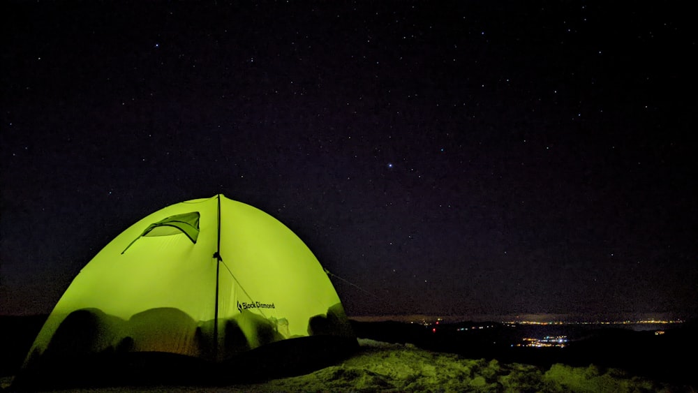 green tent on brown sand during night time