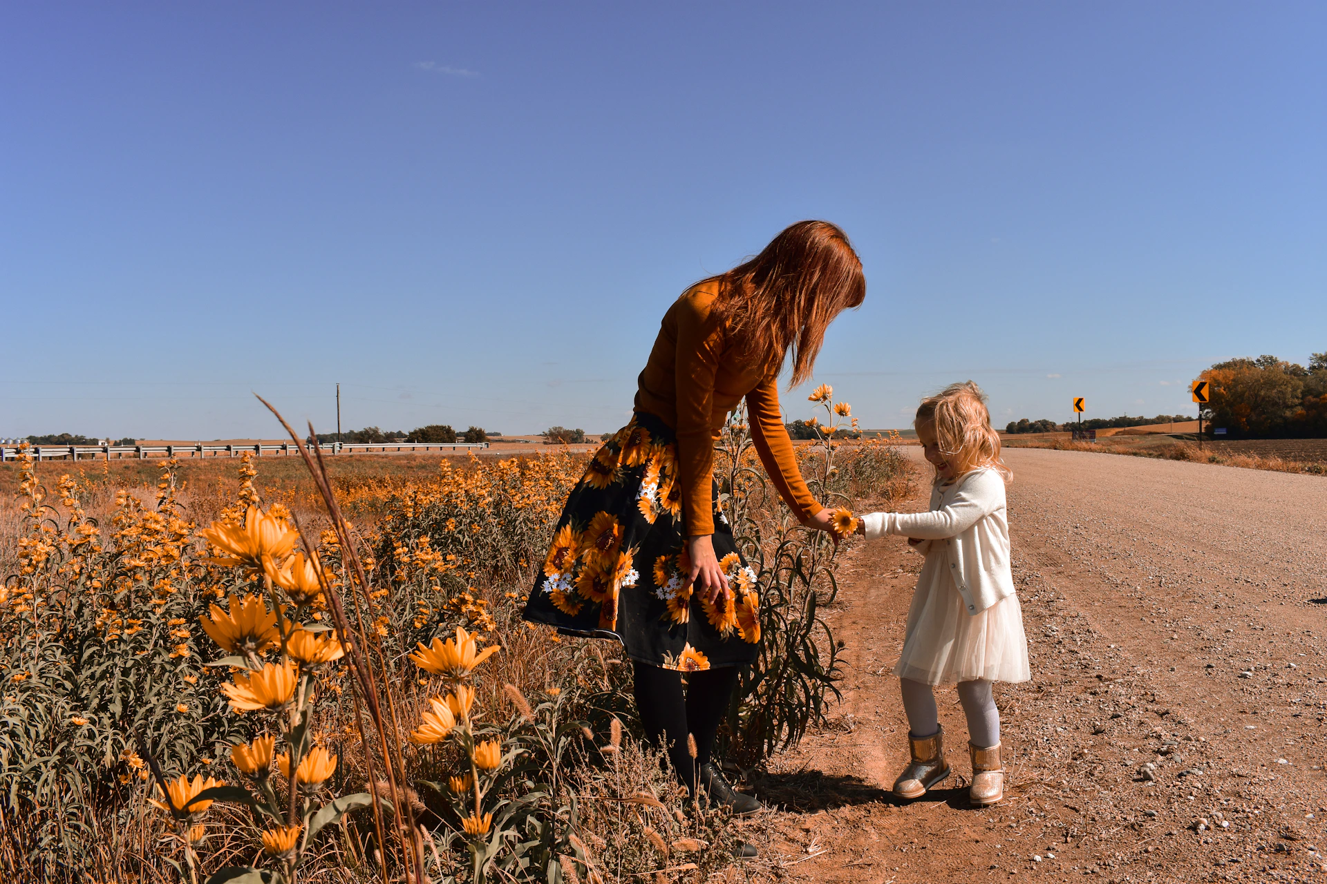 girl in white dress standing beside girl in white dress on brown grass field during daytime