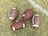 Four American footballs are placed on a grassy field with one of them lying near a white painted line. The footballs are brown with white stripes and feature the branding 'Franklin GRIP-RITE' on their surface.