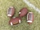 Four American footballs are placed on a grassy field with one of them lying near a white painted line. The footballs are brown with white stripes and feature the branding 'Franklin GRIP-RITE' on their surface.