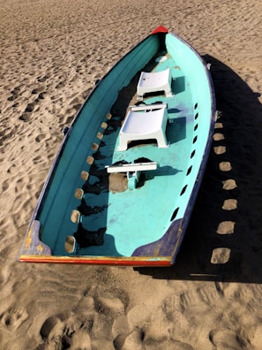 Side view of a vintage wooden boat interior featuring restored white and red padded benches.