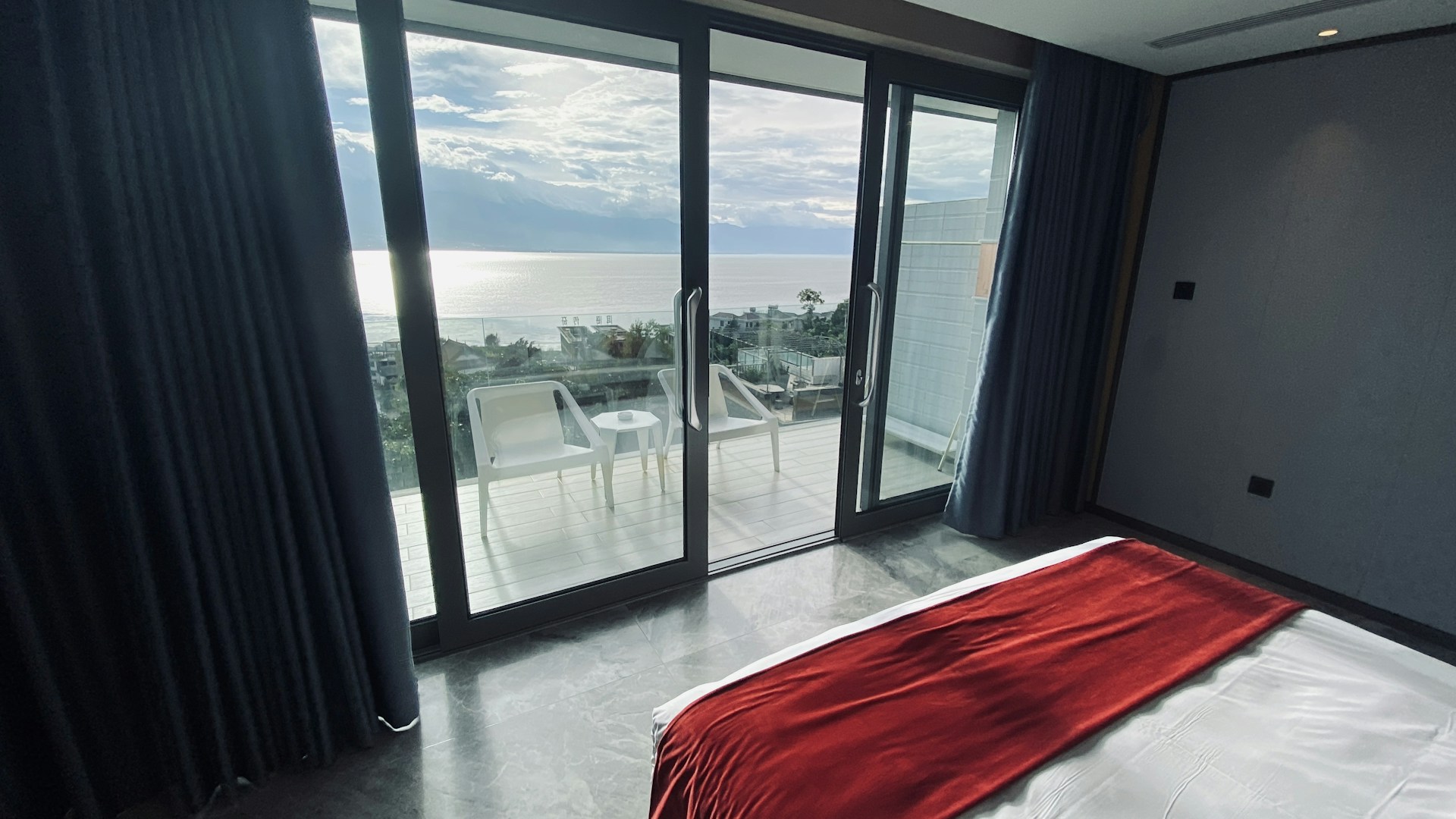 Spacious bedroom in the second apartment featuring comfortable bedding and a balcony with a sea view.
